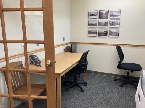 a small room with a glass door; 1 table and 2 chairs