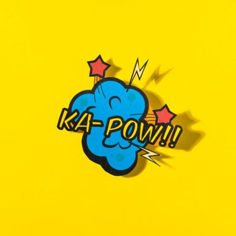 The words Ka Pow with bright yellow background and blue blob with red stars.