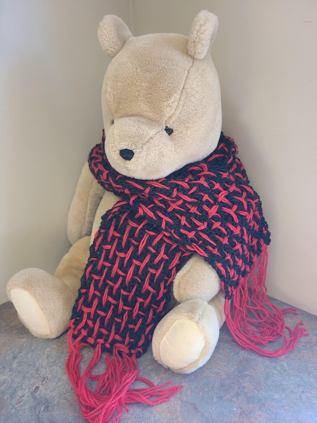 Teddy bear wearing a crocheted scarf