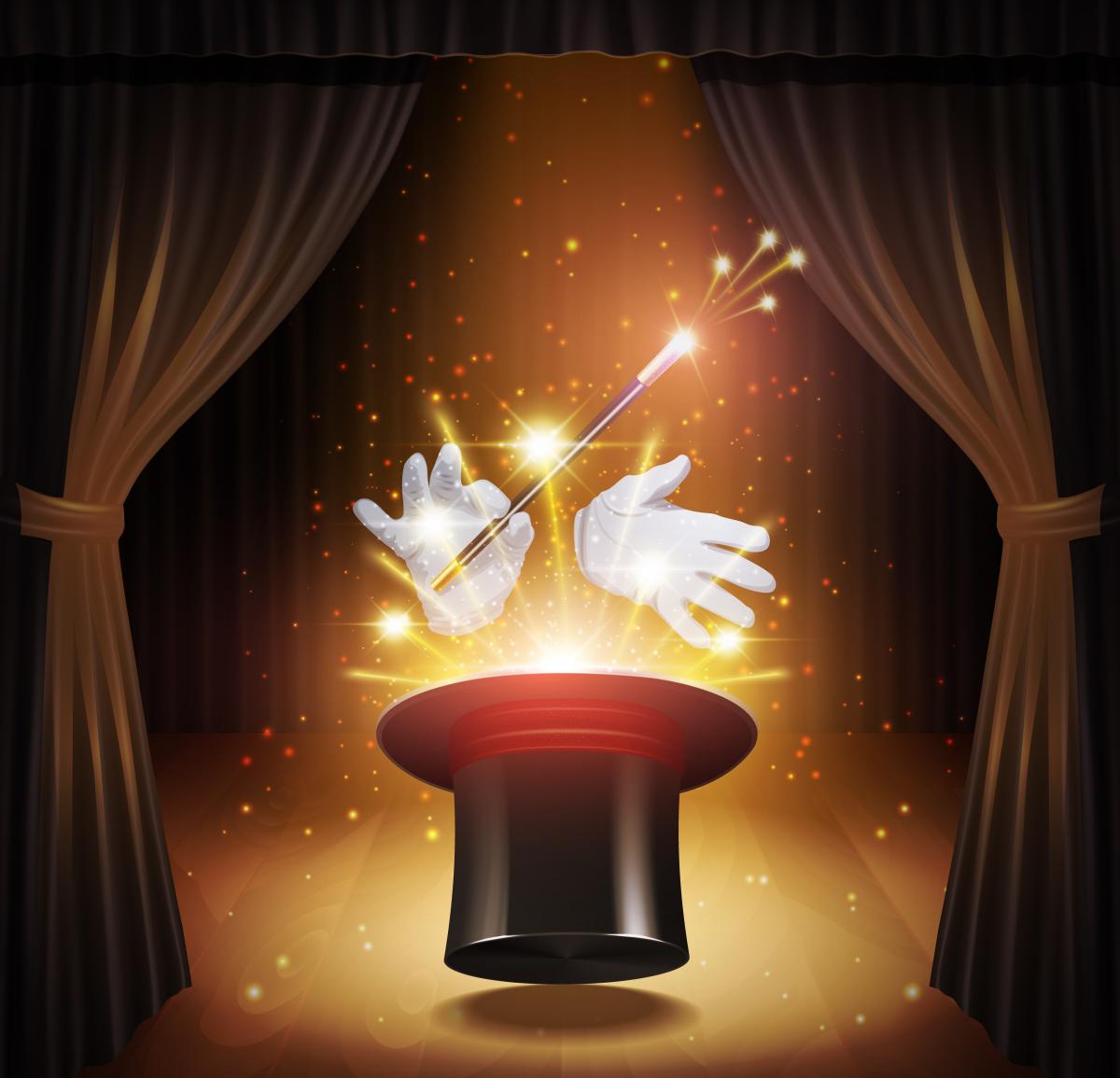 Black hat upside down on table with magic hands and sparks coming out of the top